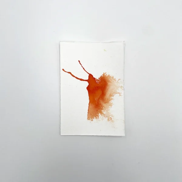 Prøve på orange tegneblæk på akvarelpapir med gradient- og spredeeffekt.