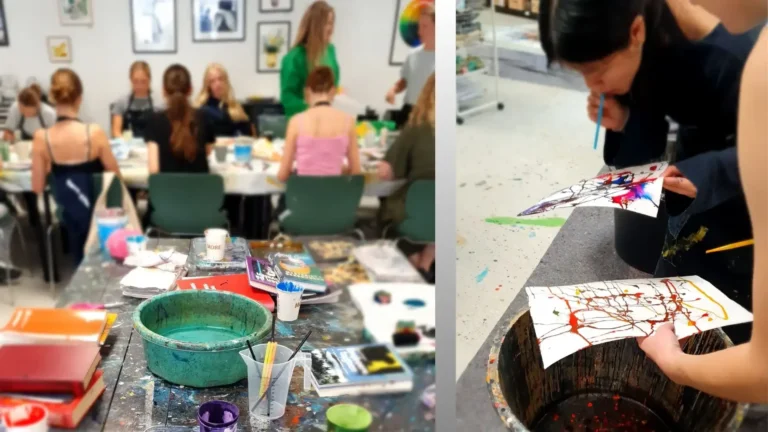 Kreativ Energi Teambuilding - Unge eksperimenterer med maling og blæseteknik på papir i et kunstværksted.